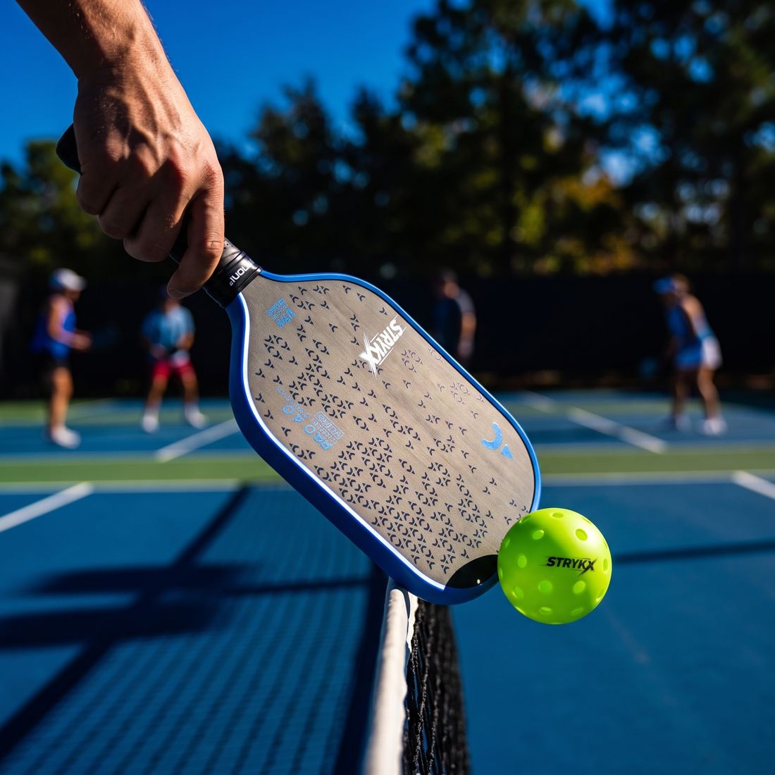Player hitting a backhand shot with a STRYKX paddle